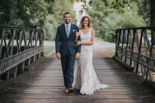 Bride and groom walking on wooden bridge